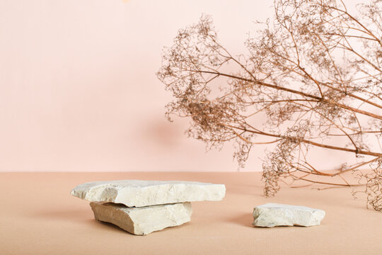Two stone catwalks with dried flowers on a beige background. Abstract eco-podium for organic products