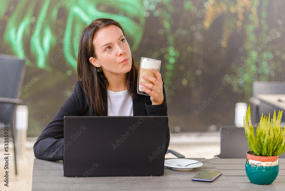 Wall mural entrepreneur with a laptop relaxing in a coffee shop outdoor and looking forward and think something