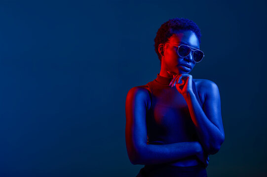 Pensive woman in sunglasses over dark background