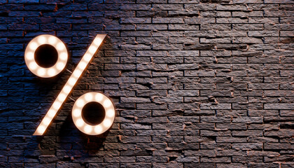 Illuminated percent sign hanging on brick wall