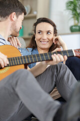 Fototapeta premium loving couple with guitar in the room at home