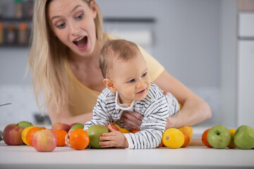 Fototapeta premium baby surrounded with fruits and vegetables