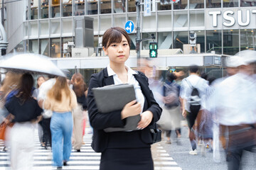 東京の繁華街を歩くスーツ姿の女性
