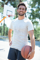 cheerful basketball player in retro glasses posing with ball