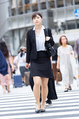 東京の繁華街を歩くスーツ姿の女性