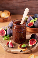 Fig jam or fig marmalade on wooden board with fresh, ripe figs