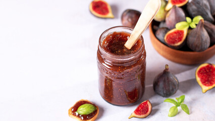Fig jam or fig marmalade on wooden board with fresh, ripe figs