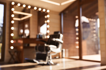 Fototapeta na wymiar Blurred view of stylish barbershop interior with hairdresser workplace