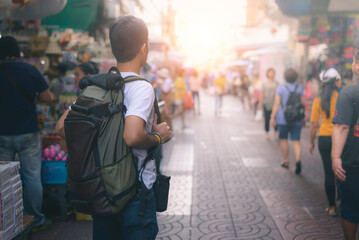 Young Asian traveling backpacker in China town Road outdoor market in Bangkok, Thailand