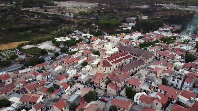 Aerial drone footage of traditional countryside village Omodos, Limassol, Cyprus. 360 view of Timios Stavros (Holy Cross) monastery, ceramic tiled roof houses and cobbled narrow streets from above.