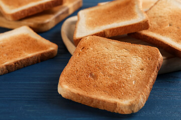 Slices of delicious toasted bread on blue wooden table, closeup