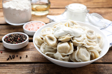 Tasty dumplings in bowl on wooden table