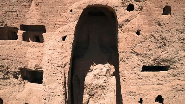Buddhas of Bamiyan Monumental Giant Statues and Caves Carved into Side Facade of Sandstone Cliff in Bamyan Valley Afghanistan, Aerial Rising Up View of Ancient Art Sculpture, Historic Archaeology Site