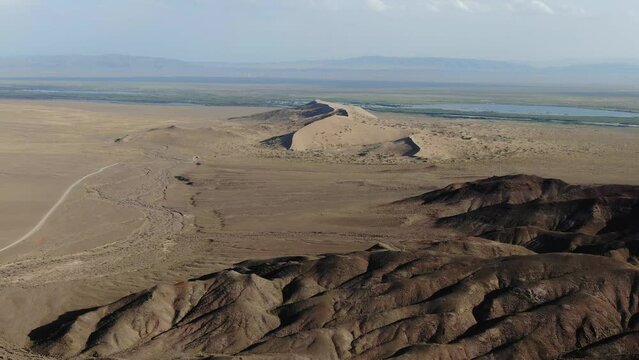 Aerial View of Desert Sandstone Mountains Hills, Singing Dunes at Altyn Emel National Park Kazakhstan, Vast Dry Arid Rough Wild Lands Terrain, Distant Brown Mountains in Horizon, Nature Landscape 