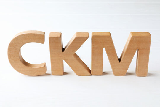 Abbreviation CKM (Customer Knowledge Management) made of letters on white wooden table