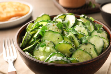 Delicious cucumber salad on wooden table, closeup