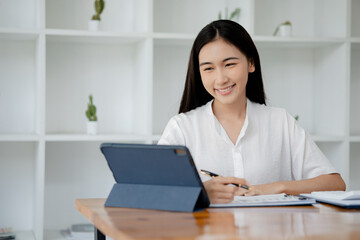 Asian woman working on laptop, female employee of a marketing company, she is working on a marketing plan for a company to generate income and profit, grow sales. Marketing planning concept.