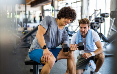 Fitness, sport, exercising concept. Fit man exercising together with his personal trainer in gym.