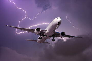 Landing airliner during a strong wind in a storm against the backdrop of a flash of lightning.