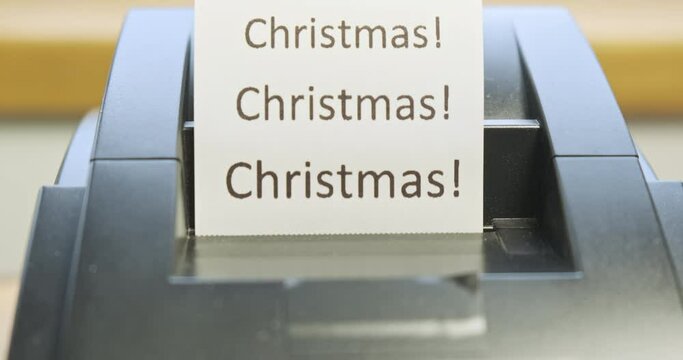 Receipt printer prints text: Christmas. Close-up, front view. The concept of promotions, sales in stores. Tear off the check