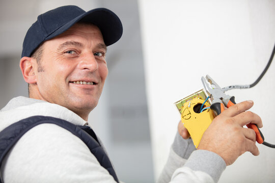 Electrician Using Multimeter And Smiling