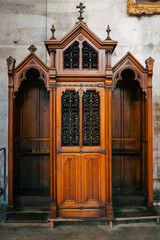 Antique wooden confessional box in dark wood in a church. Religious, Christian custom. making the...