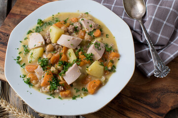 Savory stew with vegetables, potatoes, chickpeas, sausage and minced meat on a plate