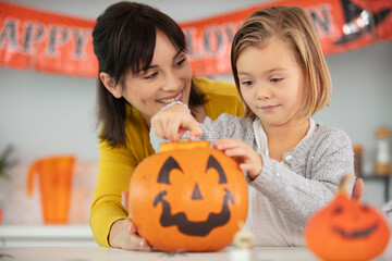 mother and daughter prepare pumpkins for halloween