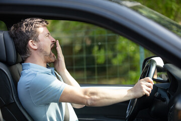 bored man in car waiting in traffic jam