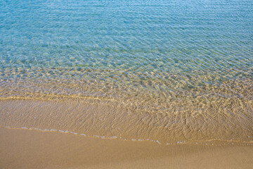 Fototapeta na wymiar The golden sundy beach and the clear waters of Manganari In Ios cyclades Greece