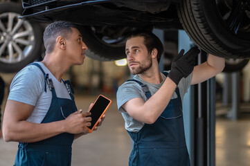 Skilled mechanics checking tires on the customer vehicle