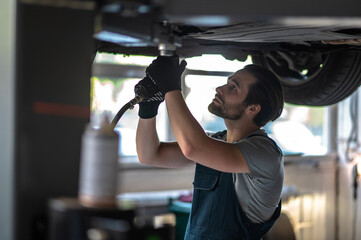 Concentrated automotive technician fixing the client vehicle