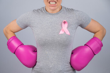 A faceless woman in pink boxing gloves with a pink ribbon holds her hands at her hips. Fight...