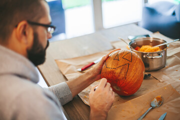 Man carving Halloween pumpkin