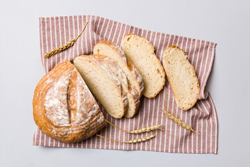 Freshly baked bread slices on napkin against natural background. top view Sliced bread