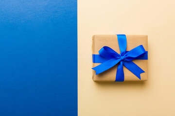 holiday handmade paper present tied blue ribbon bow top view with copy space. Flat lay holiday background. Birthday or christmas present. Christmas gift box concept with copy space