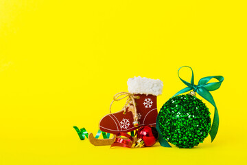 Christmas ball with skates on colored background. decoration bauble with ribbon bow with copy space