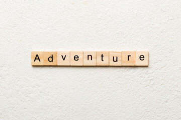 adventure word written on wood block. adventure text on cement table for your desing, concept