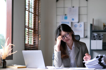 Asian woman working hard with serious emotion at office, woman working hard concept.