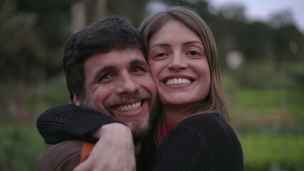 Fototapeta premium Two friends embrace. male and female people hugging each other at night standing outdoors in nature background looking at camera