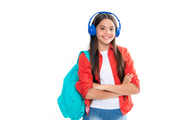 School girl in headphones on isolated studio background. School and music concept. Portrait of happy smiling teenage child girl.