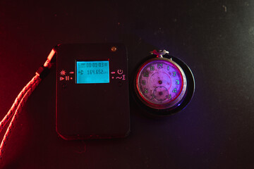 Dosimeter of radioactive radiation and old broken pocket watch with dangerous fluorescent paint....