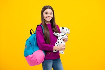 School girl hold toy. School children with favorite toys on yellow isolated background. Childhood concept.