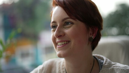 Happy red hair girl closeup face smiling. One young millennial woman in 20s portrait interacting with friends