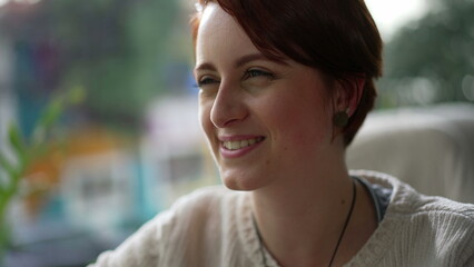 Happy red hair girl closeup face smiling. One young millennial woman in 20s portrait interacting...