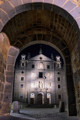 Santa Teresa church view through gate of the walls at night in Avila, Spain