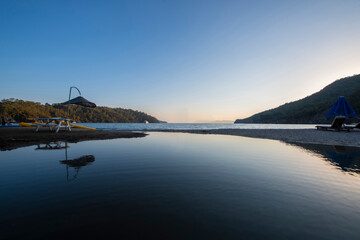 Long exposure by the sea. Waves break against stones. Sunset at the beach. Long exposure at night by the sea. Patara Beach Antalya Turkey