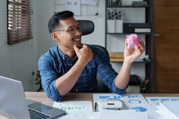 Portrait of an Asian businessman using a calculator to calculate his savings from SME operations,...