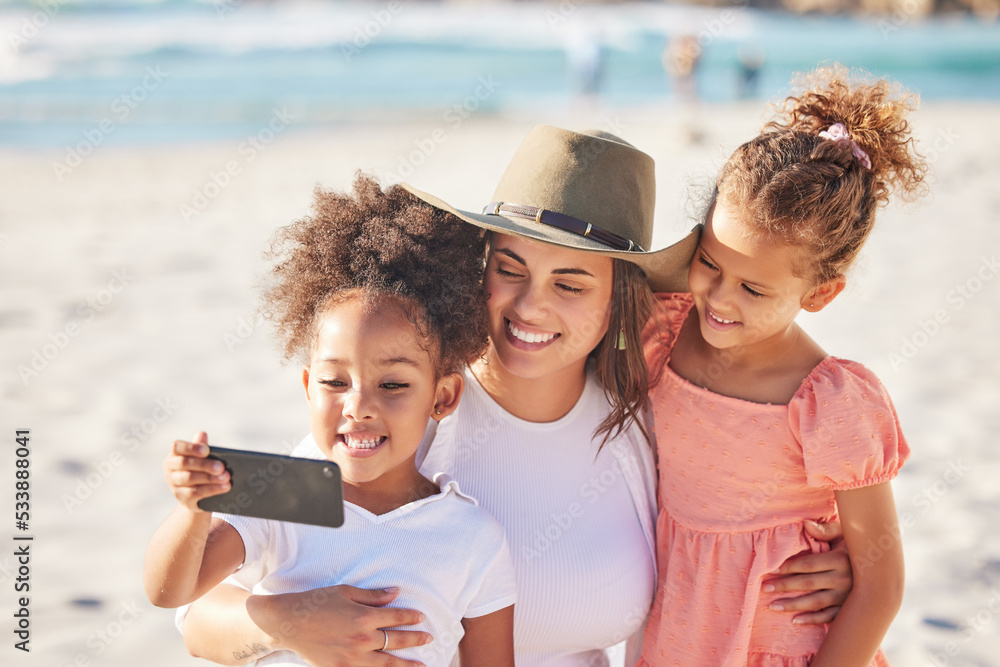 Wall mural Mom, children and beach with phone for selfie in the sunshine while on holiday together. Mother, kids and ocean take photo with smartphone in the sun on vacation or family travel to the sea