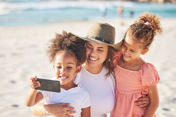 Mom, children and beach with phone for selfie in the sunshine while on holiday together. Mother,...